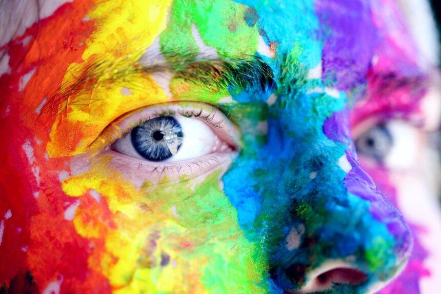 Close-up of a face coloured with rainbow colours, showing the colours of different types of personalities a person carries.