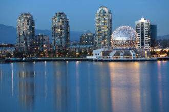 A scenic view of a waterbody beside the Science World in Vancouver during the evening time.