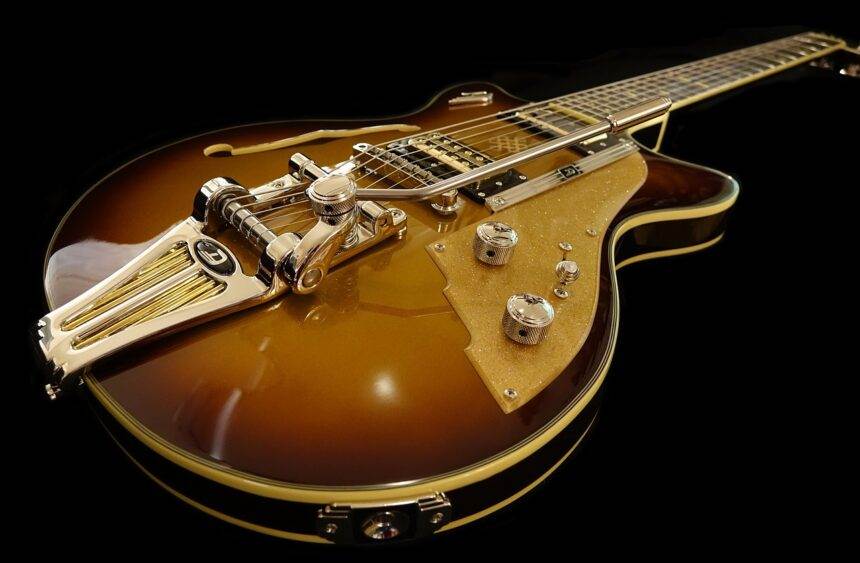 A close-up of a brown electric guitar on an isolated black background.
