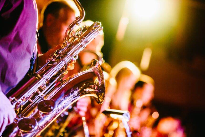 A group of musicians playing trumpet while a performance.