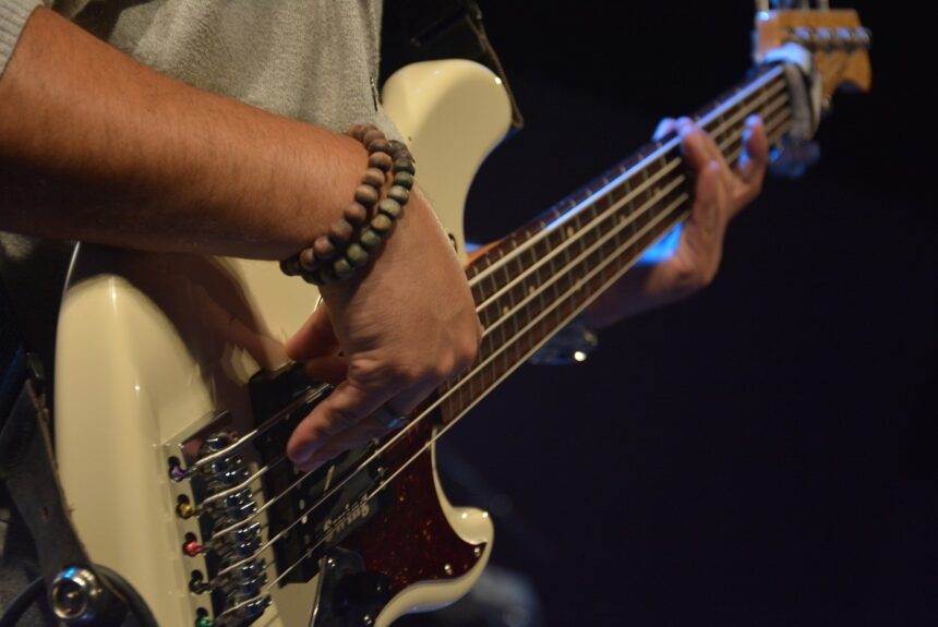 A close-up of a person's hands playing guitar.