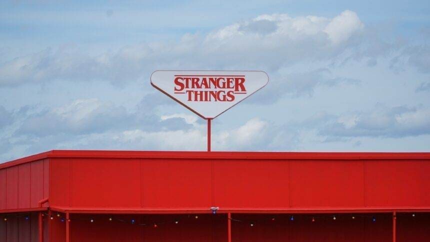 A sign board of the Stranger Things logo on the top of a building.