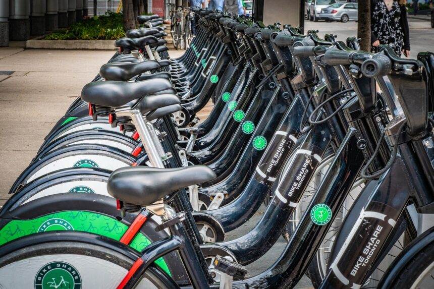 Series of bikes parked on the side of a street.