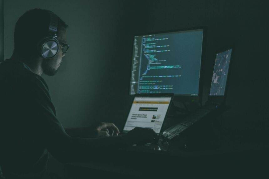 A person working on a computers doing the coding.