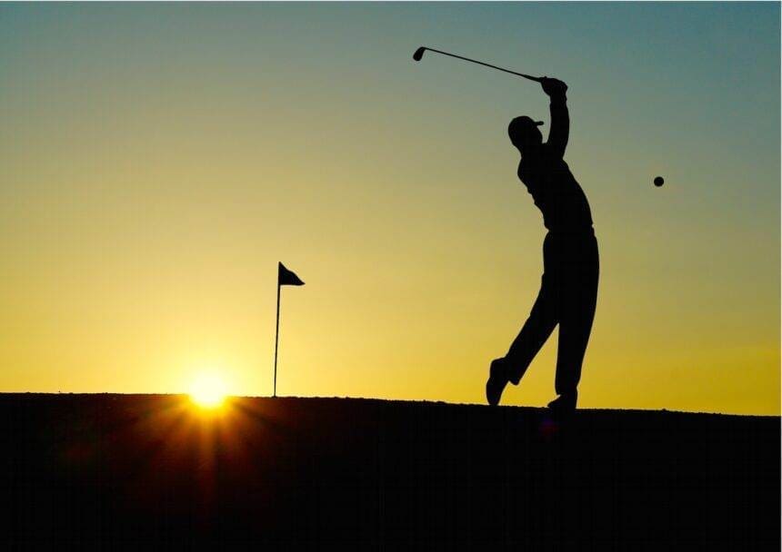 A silhouette of a person hitting the golf ball in the golf club