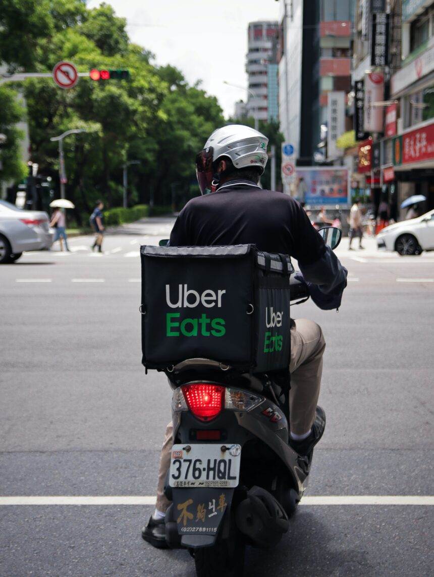 A person on his bike with the Uber Eats Box at the back to deliver the food.