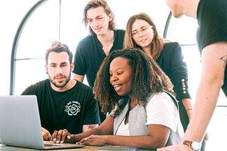 A group of people looking at the laptop screen.