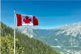 Canadian flag waving with mountainous backdrop