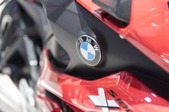 Close-up of a BMW motorcycle emblem on red bodywork.