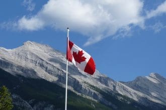 Canadian flag waving before mountainous landscape
