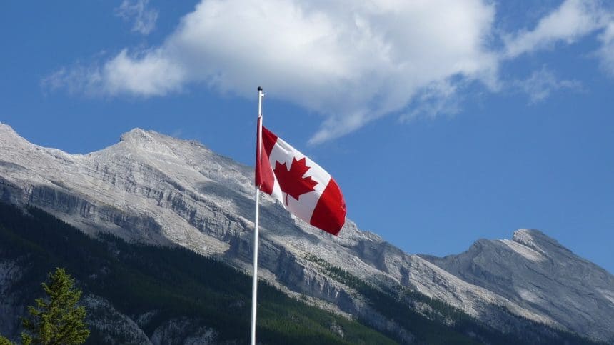 Canadian flag waving before mountainous landscape