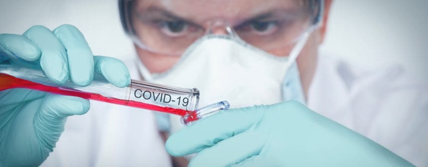 Scientist examining COVID-19 sample in lab.