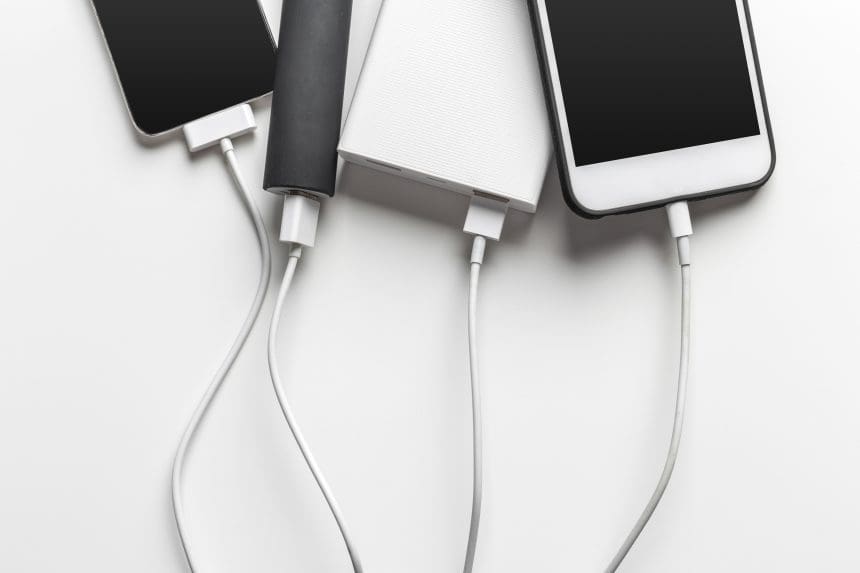 Smartphones connected to various charging cables.